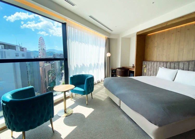 The Deluxe King room offers a panoramic view of the Sapporo cityscape from the room-length window.
